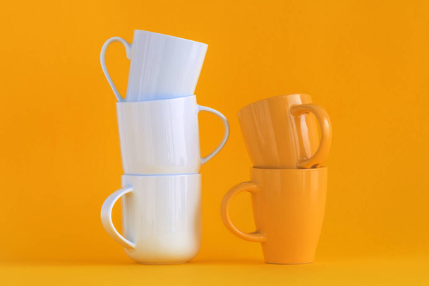 White and yellow coffee cups stack on yellow background with copy space - Foto, Imagem