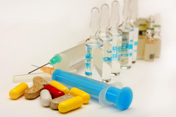 Medical ampoules,syringe and pills - blured background - Photo, Image