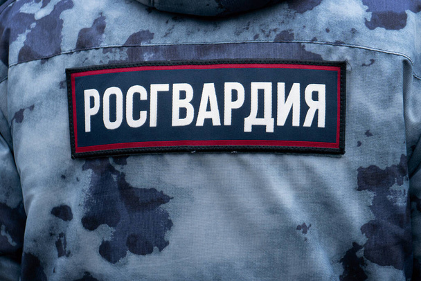 Costas de um soldado da Guarda Russa usando uniforme de camuflagem militar com etiqueta Guarda Russa
 - Foto, Imagem