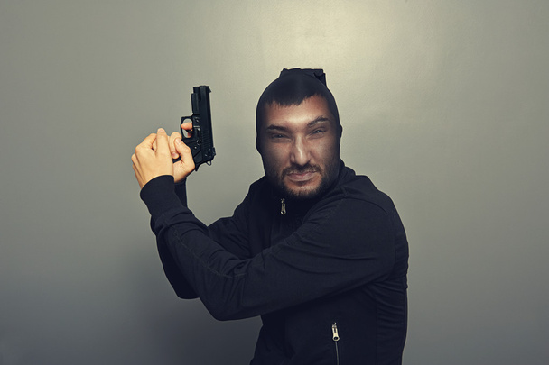 Gangster-Mann mit Pistole über Grau - Foto, Bild