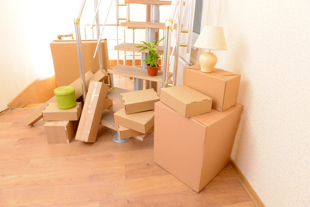 Montón de cajas de cartón cerca de escaleras: concepto de casa móvil
 - Foto, Imagen