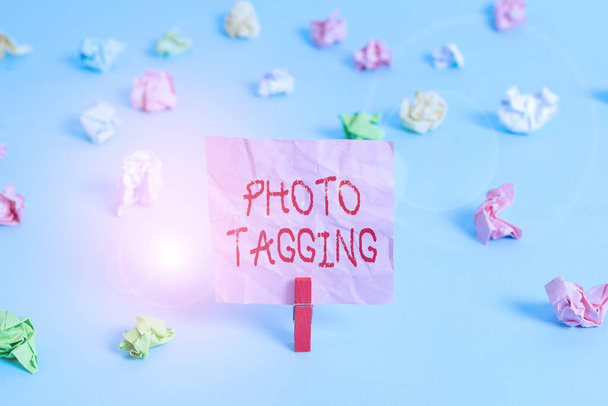 Writing note showing Photo Tagging. Business photo showcasing identify someone on the photo that you share social media Colored crumpled rectangle shaped reminder paper light blue background. - 写真・画像