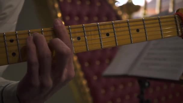 Close-up van gitarist die gitaar speelt tijdens het concert, kunst en muziek concept. Voorraadbeelden. Man muzikant in wit shirt spelen elektrische gitaar met gele nek op het evenement. - Video