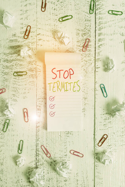 Conceptual hand writing showing Stop Termites. Business photo showcasing prevent a small tropical insect from damaging the woods Stripped ruled notepad clips paper balls wooden background. - Fotoğraf, Görsel