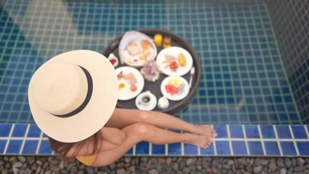 Portrét krásná mladá asijská žena šťastný úsměv s plovoucí snídaně v podnosu na bazénu - Záběry, video