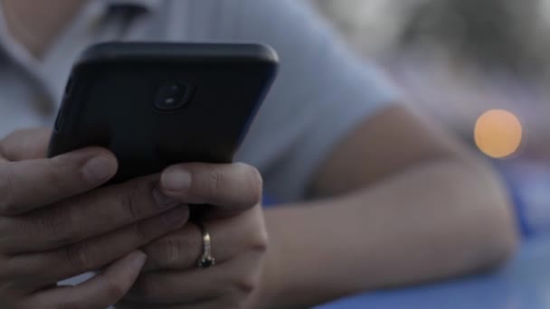 Руки женщины отправляют сообщения на мобильный смартфон для общения и чата в соцсети на рынке уличной еды ночью. Ночной рынок освещения боке фон
. - Кадры, видео