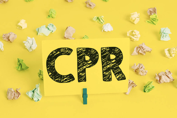 Text sign showing Cpr. Conceptual photo cardiopulmonary resuscitation Method used to keep someone alive Colored crumpled papers empty reminder white floor background clothespin. - Photo, Image
