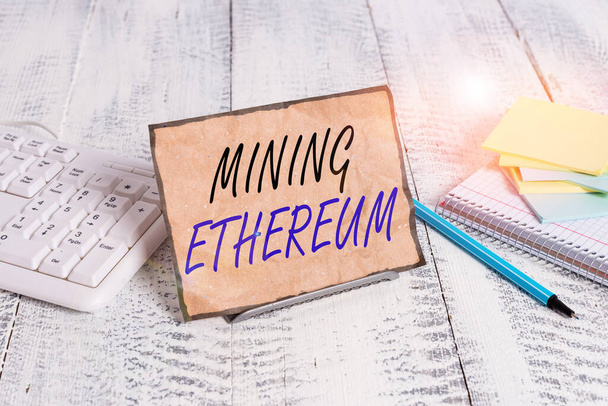 Conceptual hand writing showing Mining Ethereum. Business photo text the process of increasing the volume of Ether in circulation Notepaper on wire in between computer keyboard and sheets. - Zdjęcie, obraz
