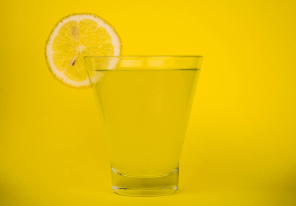  Szklanka świeżego soku cytrynowego na żółtym tle. - Zdjęcie, obraz