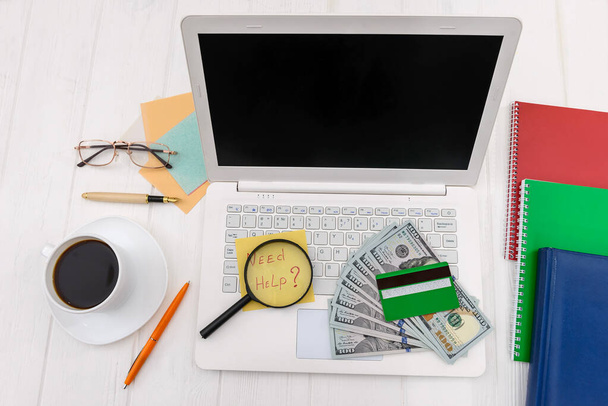 Dollars with credit card and magnifier on laptop keyboard  - Foto, Imagen