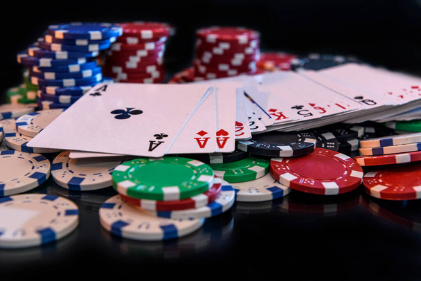 Playing cards with poker chips at black background - Foto, afbeelding