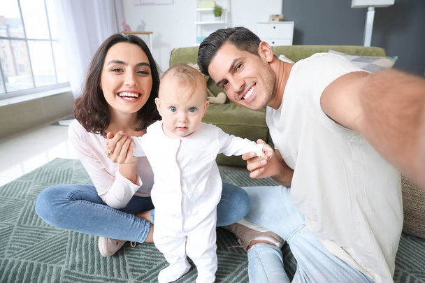 Cute baby with parents taking selfie at home - Foto, afbeelding