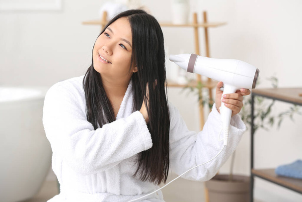Gyönyörű ázsiai nő hajszárítóval otthon - Fotó, kép