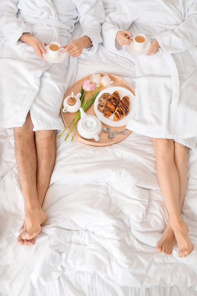 Giovane coppia che fa colazione a letto a casa
 - Foto, immagini