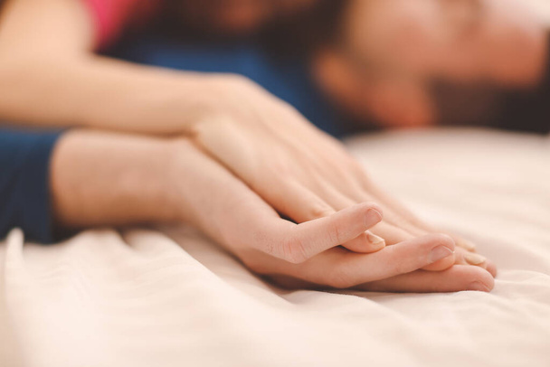 Hands of young couple sleeping in bed - Foto, Imagem