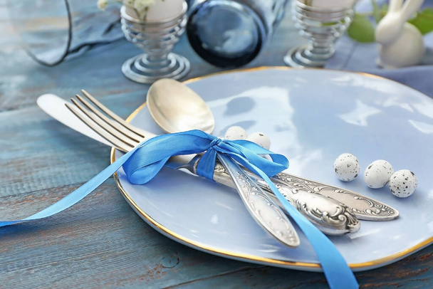 Beautiful Easter table setting on color wooden background - Foto, imagen