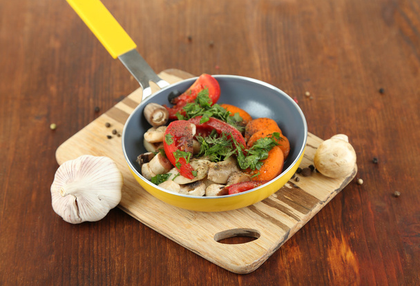 Sliced fresh vegetables in pan on wooden table close-up - Foto, Imagem