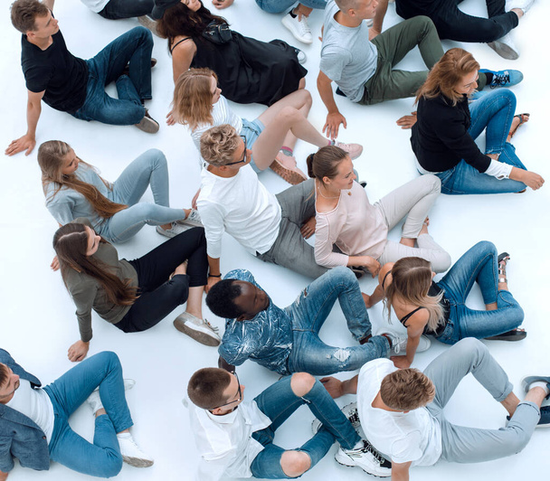 large casual group of young people sitting on the floor. - Fotoğraf, Görsel