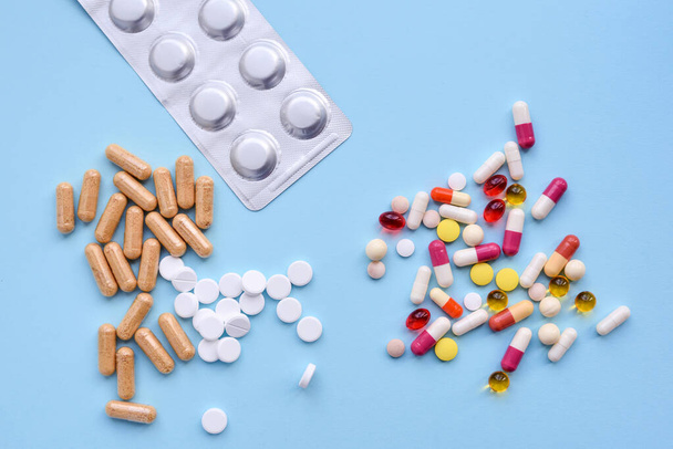Sortiment farmaceutické medicíny pilulky, tablety a tobolky přes modré pozadí. Horní pohled - Fotografie, Obrázek
