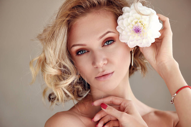 Portret młodej blondynki z białym kwiatem - Zdjęcie, obraz