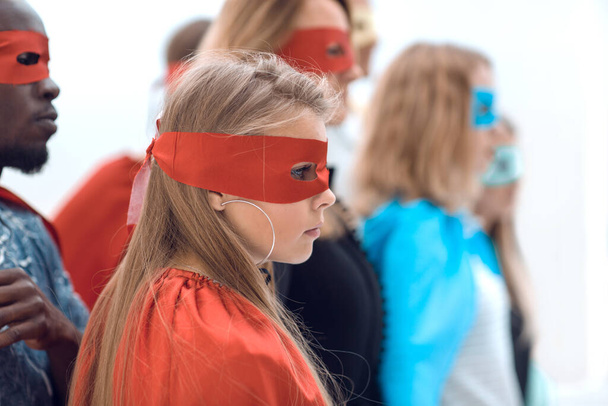 serious superhero girl standing with her friends. - Foto, afbeelding