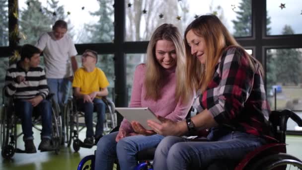 Smějící se zdravotně postižené ženy na invalidním vozíku pomocí tablet - Záběry, video