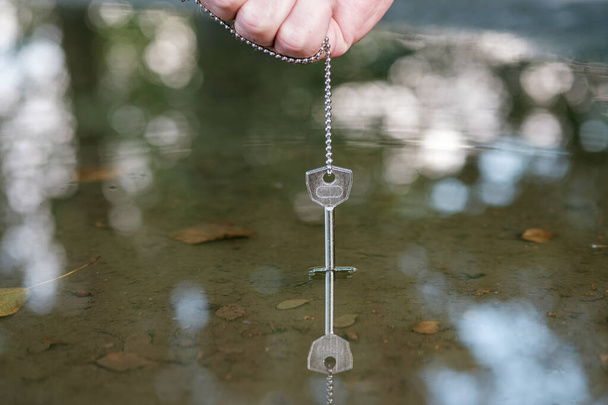 metalliketjun avain lasketaan veteen hukuttamaan todisteita
 - Valokuva, kuva