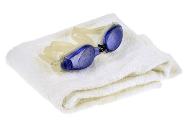 Occhiali da bagno su un asciugamano bianco primo piano su sfondo bianco
 - Foto, immagini