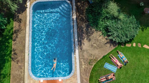 Happy family relaxing by swimming pool, aerial drone view from above of parents and kids have fun on vacation, family weekend on resort - Fotografie, Obrázek