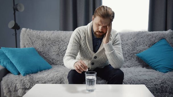 Man suffering headache taking medicine - Foto, afbeelding