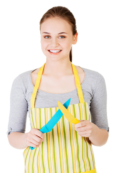 Attractive woman in kitchen apron with knives. - Zdjęcie, obraz