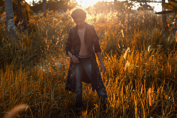 młoda stylowa kobieta nosi sylwetkę płaszcza na zewnątrz o zachodzie słońca - Zdjęcie, obraz