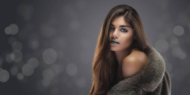 Beautiful brunette woman. evening make-up in the fur coat on the gray bokeh background - Foto, Imagem