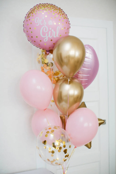 Palloncini rosa e dorati con il testo "è una ragazza" di genere rivelano festa. Festa di genere
 - Foto, immagini