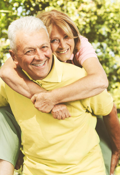 Πορτρέτο του ευτυχισμένου ηλικιωμένου ζευγαριού ερωτευμένων, ηλικιωμένων γυναικών και ανδρών στο πάρκο. - Φωτογραφία, εικόνα