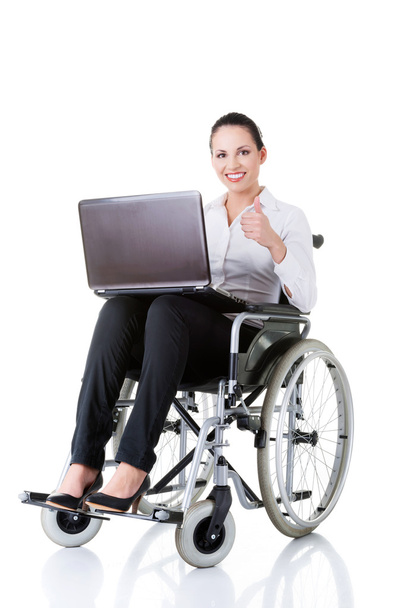 Business woman sitting on wheelchair, showing OK. - Zdjęcie, obraz