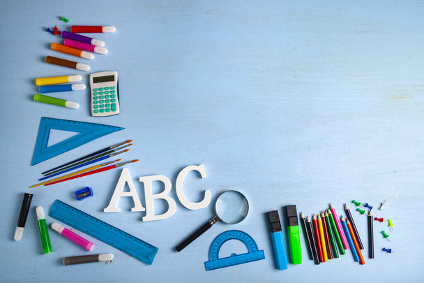 Возвращайся в школу. Предметы для школы и буквы ABC на деревянном столе. Место для текста
. - Фото, изображение