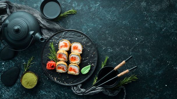 Sushi rolls with tuna and caviar. Sushi set on a black stone plate. Top view. - Φωτογραφία, εικόνα