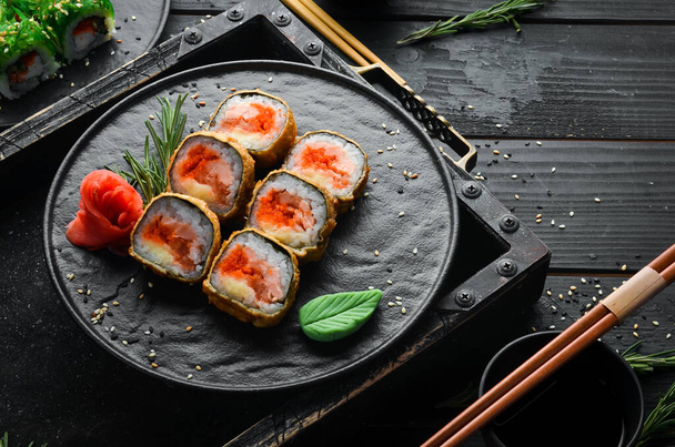 Sushi rolls with tuna and caviar. Sushi posazené na černém kamenném talíři. Horní pohled. - Fotografie, Obrázek
