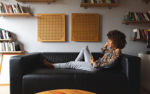 Casual woman enjoying leisure at home reading on a tablet. - Valokuva, kuva