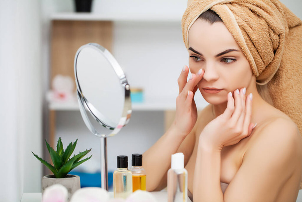 vrouw klaar voor werk doen ochtend make-up in badkamer spiegel thuis - Foto, afbeelding