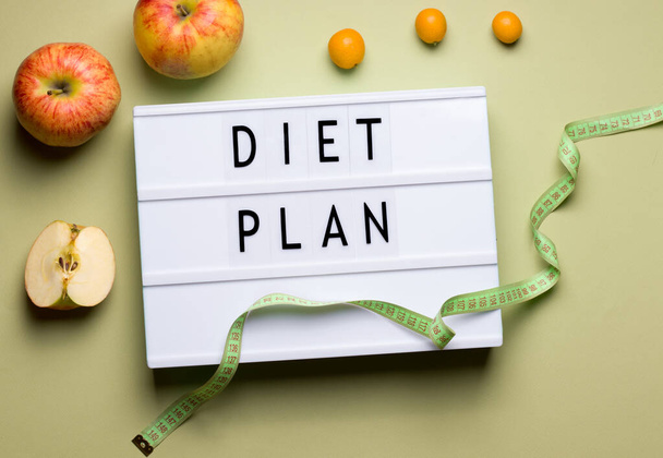 diet plan concept on green blackboard background with the inscription, next to fruits apples and kumquat - Foto, imagen
