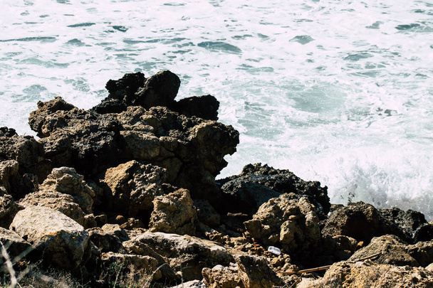 Waves of the Mediterranean sea break against a rock on Paphos beach in Cyprus - Foto, imagen