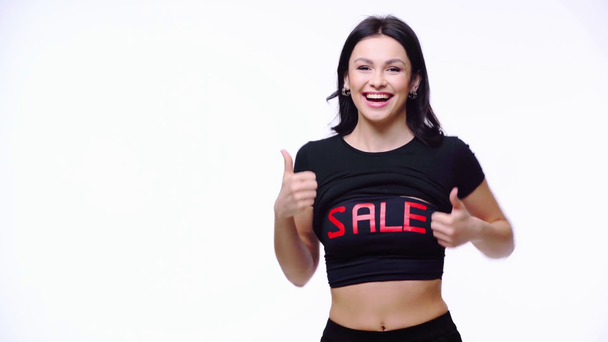Šťastná žena ukazuje top s prodejem písmena izolované na bílém - Záběry, video