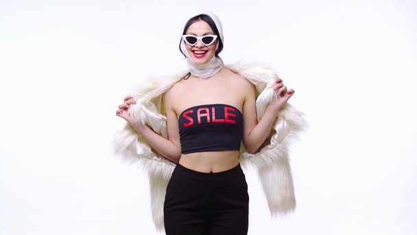 Femme élégante en fausse fourrure montrant top avec vente lettrage isolé sur blanc
 - Séquence, vidéo