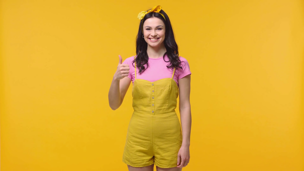 Γυναίκα που δείχνει σαν σημάδι και χαμογελά απομονωμένη στο κίτρινο - Πλάνα, βίντεο