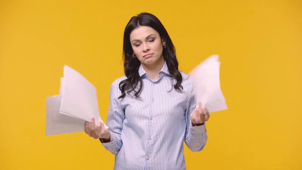 Tired businesswoman with papers isolated on yellow - Footage, Video