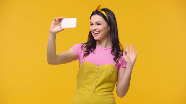 Vrouw neemt selfie geïsoleerd op geel - Video