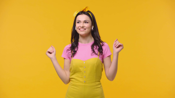 Woman with earphones dancing isolated on yellow - Video, Çekim