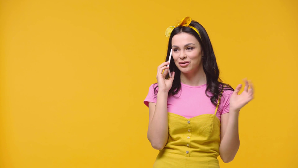 Mujer hablando en smartphone aislado en amarillo
 - Imágenes, Vídeo